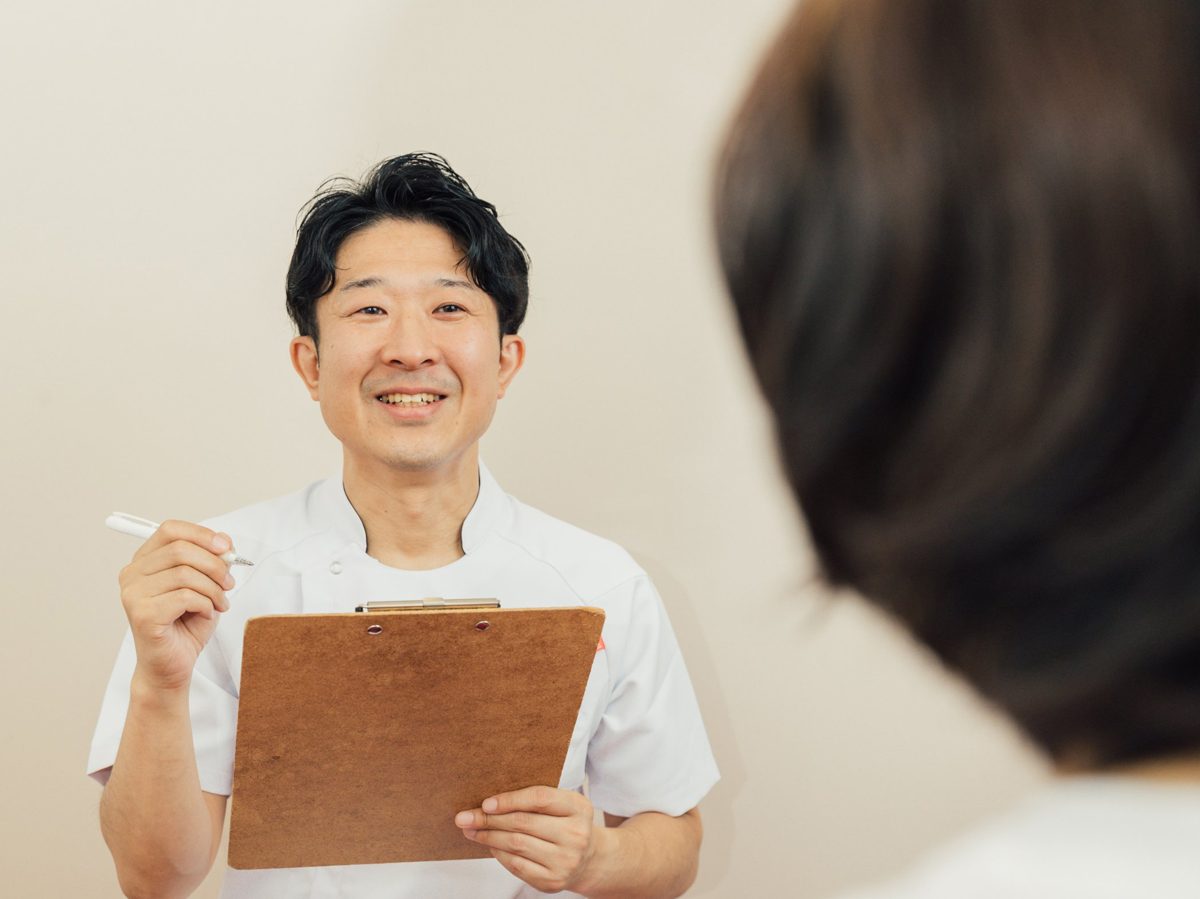 笑顔でカウンセリングをする代表の小川太郎